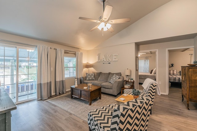 living room with ceiling fan, wood-type flooring, and lofted ceiling