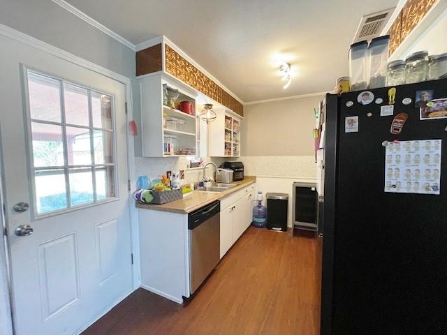 kitchen with dishwasher, dark hardwood / wood-style floors, black fridge, and white cabinetry