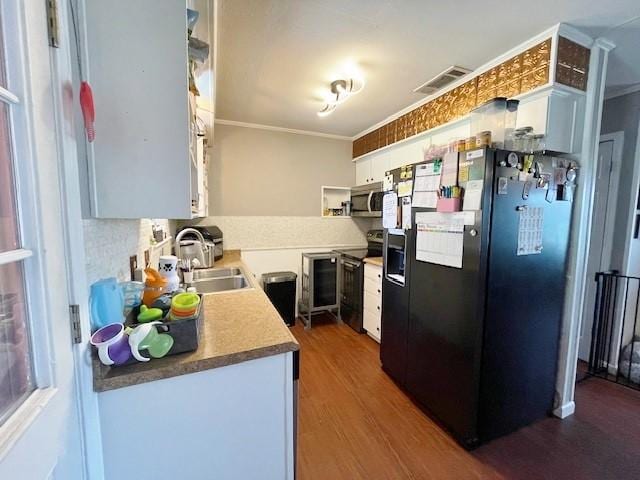 kitchen with white cabinetry, sink, stainless steel appliances, dark hardwood / wood-style floors, and ornamental molding