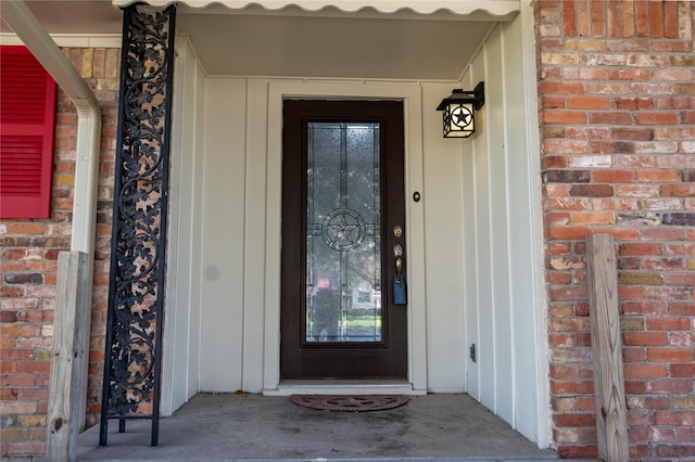 doorway to property featuring brick siding