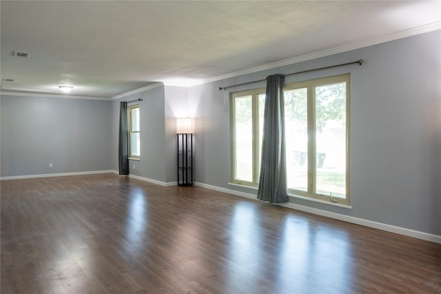 spare room with crown molding, plenty of natural light, and dark wood-style floors