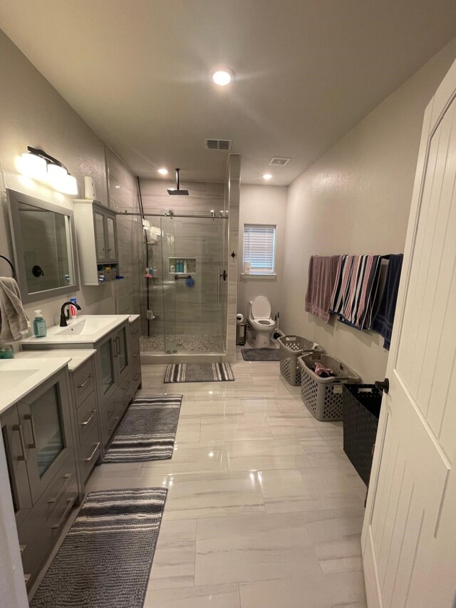 bathroom with a shower with door, vanity, and toilet