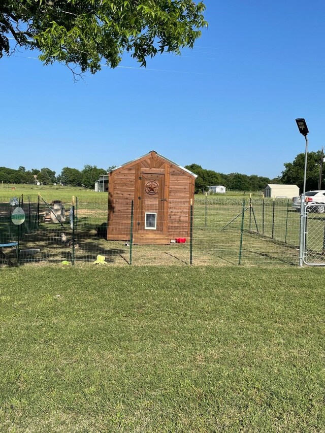 view of outdoor structure with a lawn and a rural view