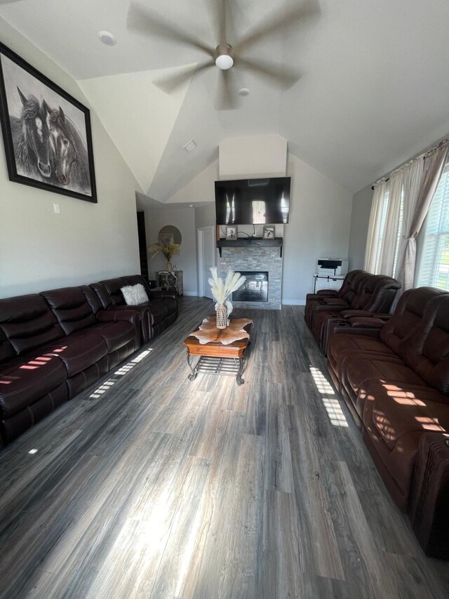 living room with a fireplace, hardwood / wood-style flooring, vaulted ceiling, and ceiling fan