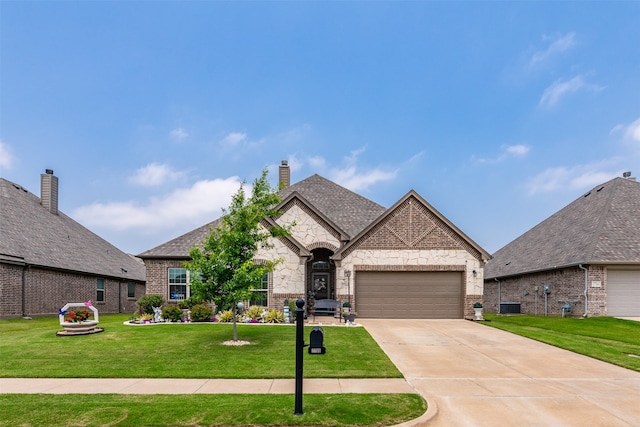 view of front of home featuring central AC, a front lawn, and a garage