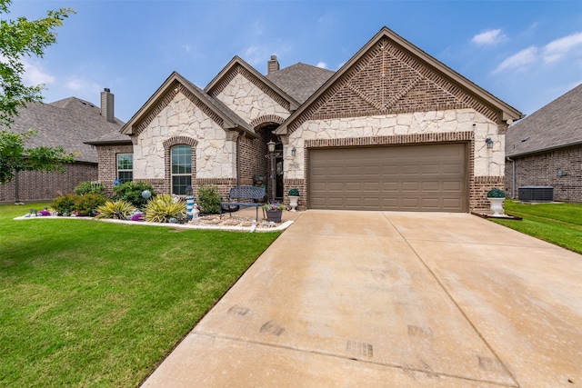 french country style house featuring a front lawn and a garage