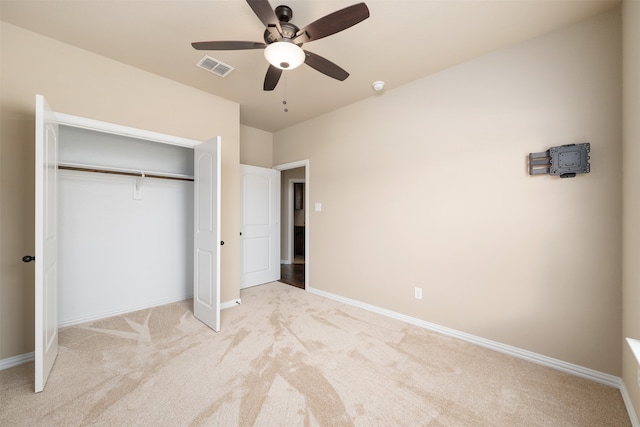 unfurnished bedroom with ceiling fan, a closet, and light carpet