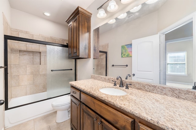 full bathroom with tile patterned flooring, vanity, combined bath / shower with glass door, and toilet