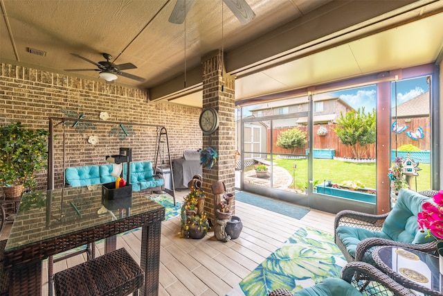 sunroom / solarium featuring ceiling fan