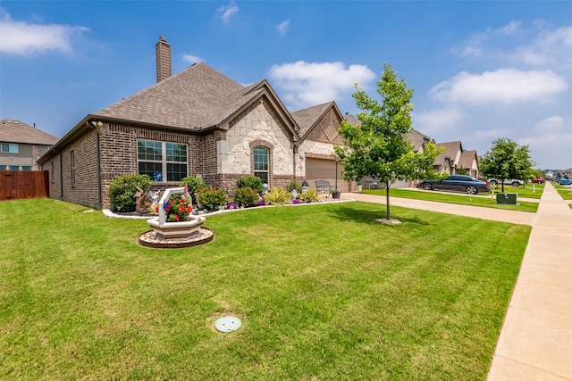 view of front of property featuring a garage and a front lawn