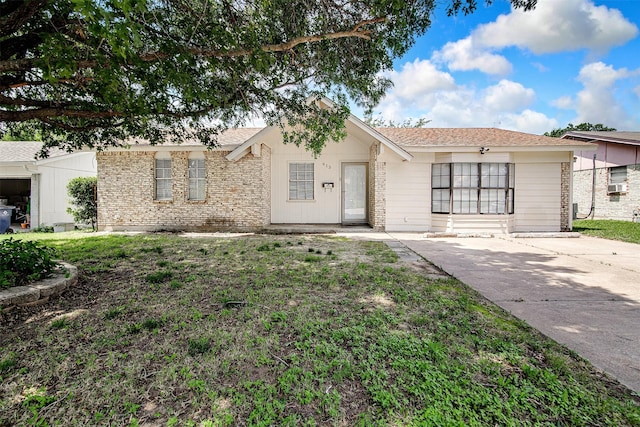 ranch-style house featuring a front yard and cooling unit