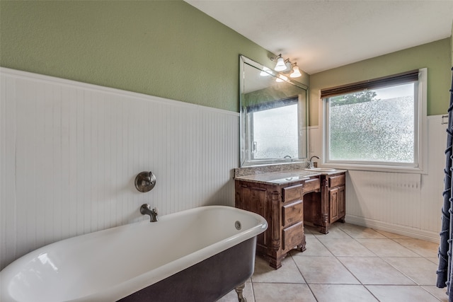 bathroom featuring tile floors, a tub, and vanity