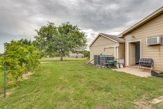 view of yard featuring a patio area, central AC unit, and a wall mounted air conditioner