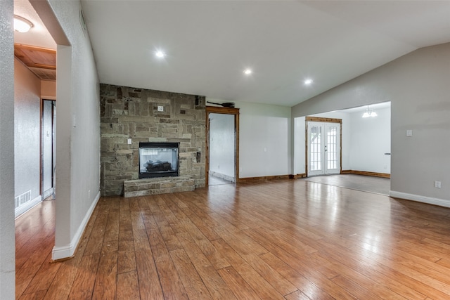 unfurnished living room featuring wood-type flooring, a fireplace, and vaulted ceiling