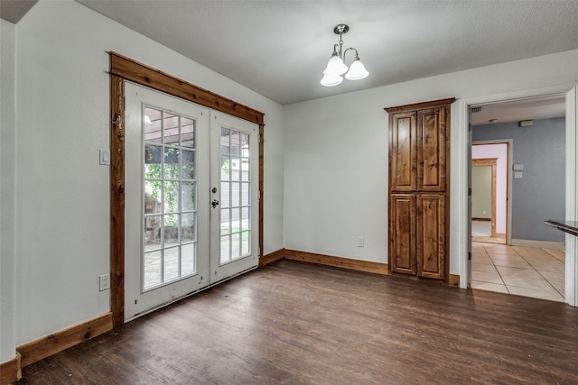 entryway featuring an inviting chandelier, a textured ceiling, french doors, and wood-type flooring