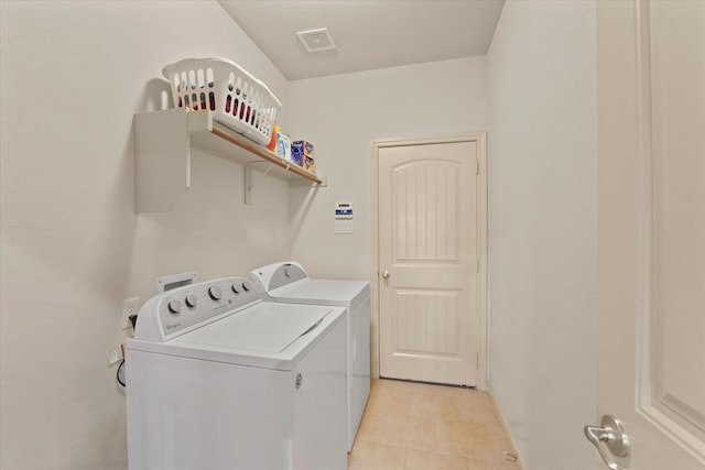 laundry area featuring separate washer and dryer and light tile patterned flooring