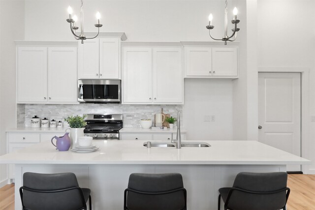 kitchen with sink, light hardwood / wood-style flooring, dishwasher, and a kitchen island with sink