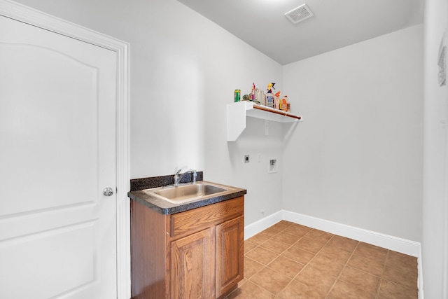 clothes washing area with washer hookup, electric dryer hookup, light tile patterned floors, and sink