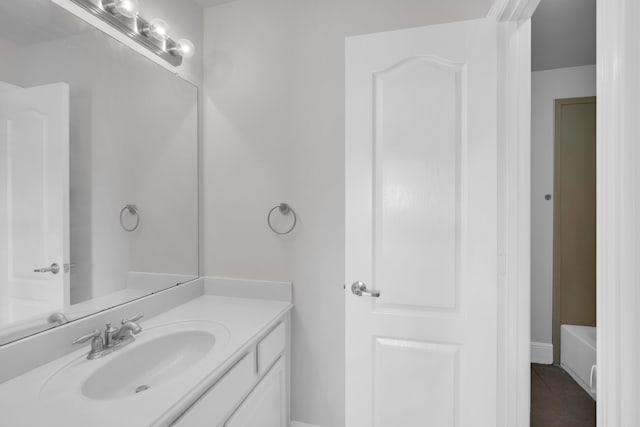 bathroom featuring tile patterned flooring, vanity, and a tub to relax in