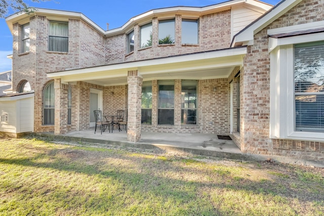 rear view of house featuring a yard and a patio