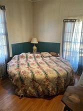 bedroom with multiple windows and hardwood / wood-style flooring