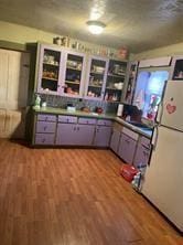 kitchen with white fridge and hardwood / wood-style flooring