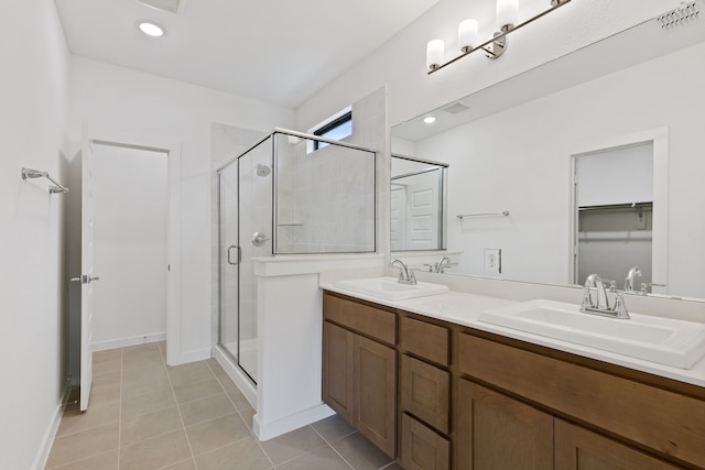 bathroom featuring tile patterned flooring, vanity, and a shower with shower door