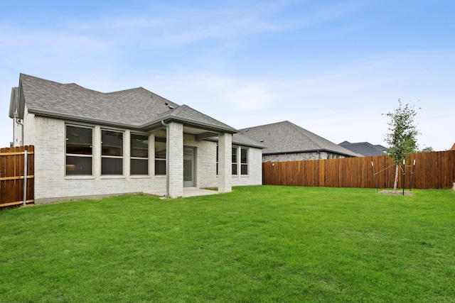 back of property with a lawn and a patio