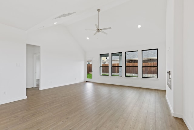 unfurnished room with ceiling fan, high vaulted ceiling, and light hardwood / wood-style floors