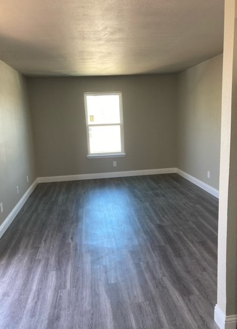 empty room with dark hardwood / wood-style floors