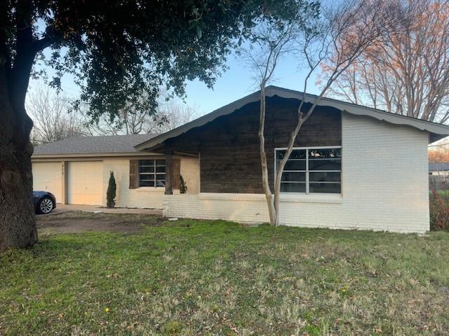 exterior space featuring a garage and a front lawn