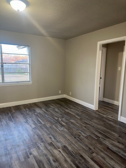 unfurnished room with dark hardwood / wood-style flooring and a textured ceiling