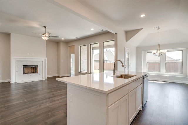 kitchen featuring a high end fireplace, a kitchen island with sink, sink, ceiling fan with notable chandelier, and hanging light fixtures