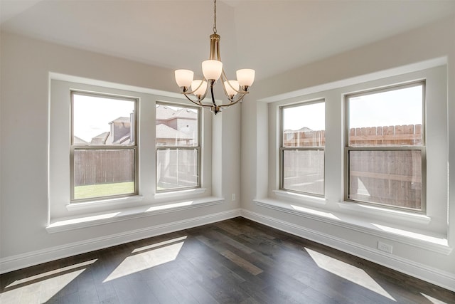 unfurnished dining area featuring an inviting chandelier and dark wood-type flooring