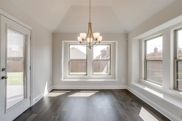 unfurnished dining area featuring a notable chandelier, lofted ceiling, and dark hardwood / wood-style flooring