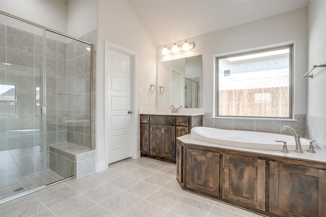 bathroom featuring independent shower and bath, vanity, vaulted ceiling, and tile patterned floors