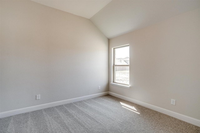 empty room with carpet and vaulted ceiling