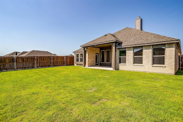 back of house with a patio area and a yard