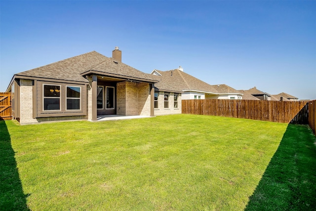 back of house with a yard and a patio area