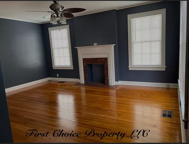 unfurnished living room featuring crown molding, ceiling fan, a fireplace, and hardwood / wood-style floors