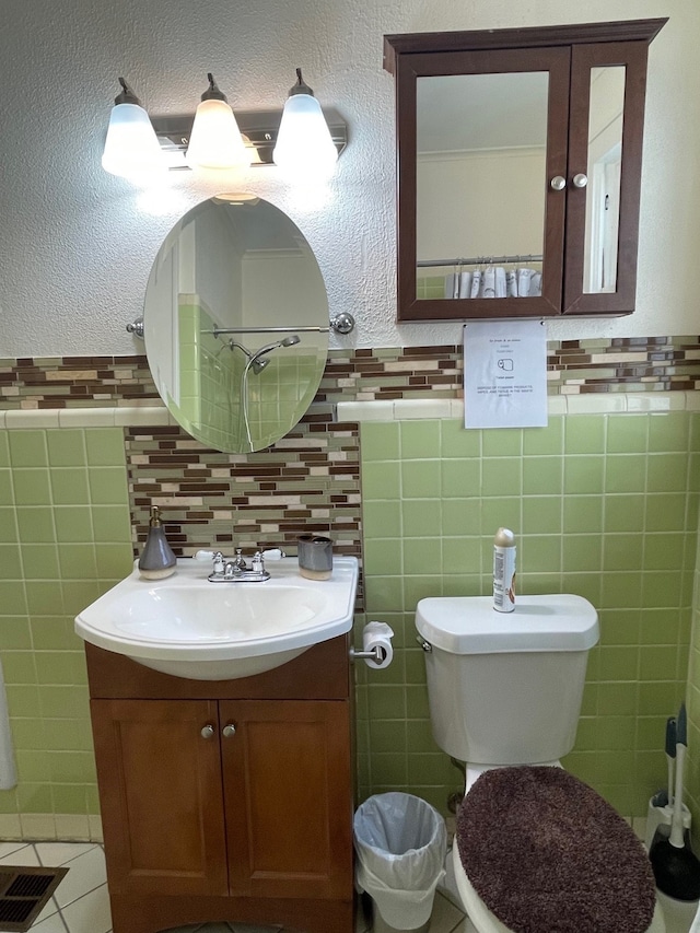 bathroom with vanity, tile patterned flooring, decorative backsplash, toilet, and tile walls