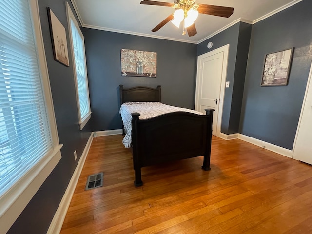 bedroom featuring ceiling fan, hardwood / wood-style flooring, and ornamental molding