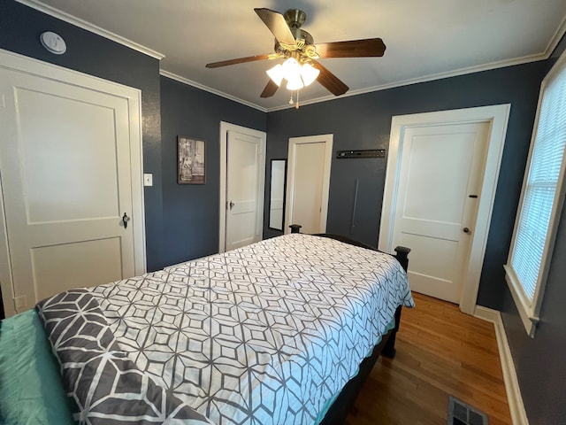 bedroom with dark hardwood / wood-style floors, ceiling fan, and ornamental molding