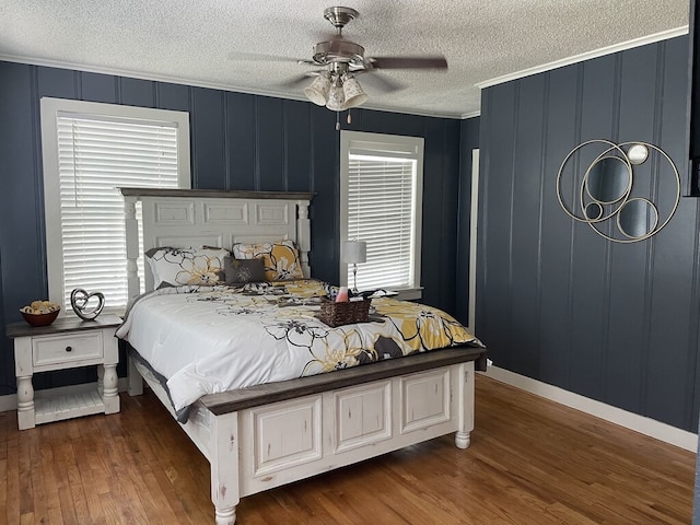 bedroom featuring ceiling fan, dark hardwood / wood-style flooring, crown molding, and multiple windows