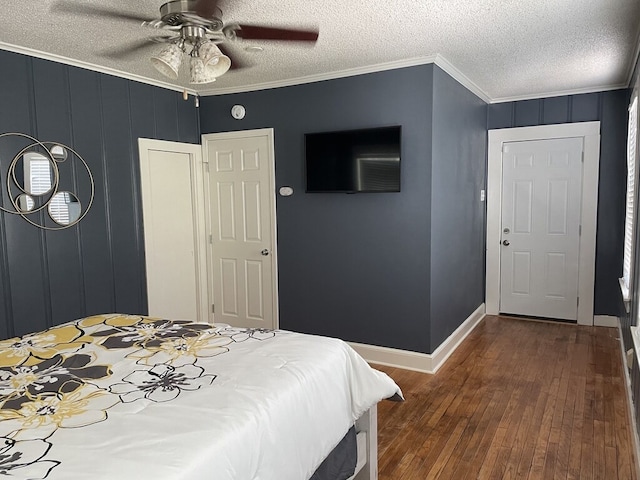 bedroom with a textured ceiling, ceiling fan, ornamental molding, and dark wood-type flooring