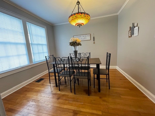 dining area with plenty of natural light, wood-type flooring, and ornamental molding