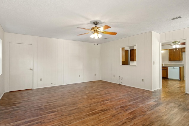 spare room with a textured ceiling, ceiling fan, and dark hardwood / wood-style floors