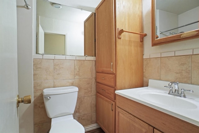 bathroom with vanity, tile walls, and toilet