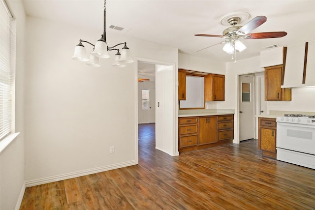 kitchen featuring white range oven, ceiling fan with notable chandelier, pendant lighting, and dark hardwood / wood-style floors