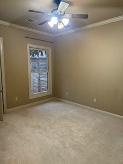 spare room featuring ceiling fan, crown molding, and light carpet